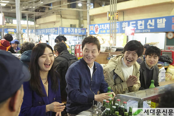 재래시장을 찾은 청년들과 음식을 나누며 대화하는 정두언 국회의원