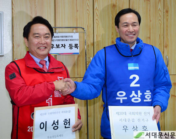 이성헌.우상호 후보가 등록을 마친후 악수하며 깨끗한 승부를 다짐하는 모습